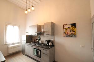 a kitchen with a stove and a refrigerator at Nora's House in Siena