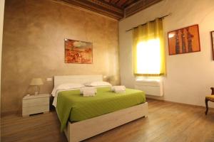 1 dormitorio con 1 cama con manta verde en Nora's House, en Siena