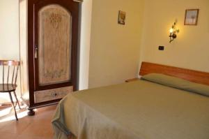 1 dormitorio con 1 cama y 1 silla en una habitación en Villa kate, en Taormina