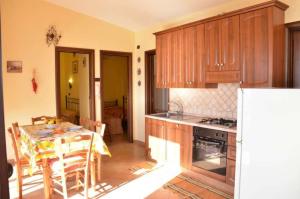 una cocina con armarios de madera y una mesa con comedor. en Villa kate, en Taormina