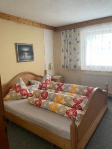 Schlafzimmer mit einem Bett mit bunten Kissen in der Unterkunft Gästehaus Wieshof in Vent