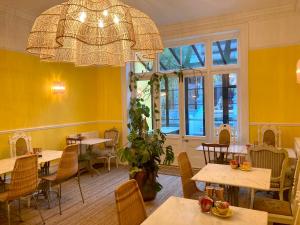 um restaurante com mesas e cadeiras e um lustre em 15 Grosvenor em Hastings