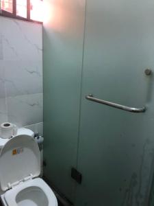 a bathroom with a toilet and a glass door at Montrose Gardens in Lagos