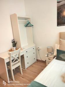 a bedroom with a dresser and a desk with a mirror at Hostal Ventura Premium in Alicante