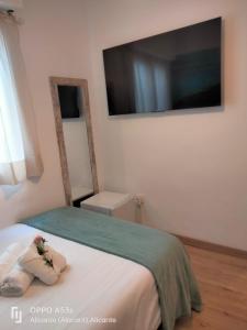 sypialnia z łóżkiem z telewizorem na ścianie w obiekcie Hostal Ventura Premium w Alicante