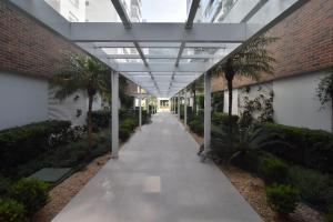 a walkway in a building with a glass ceiling at Apto 2 quartos, 350 mts Primavera Garden e ACM P2079 in Florianópolis