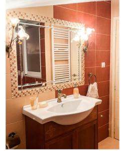 a bathroom with a sink and a mirror at BLUE CAVE LUXURY MAISONETTE View to the Corinthian Sea in Xylokastron