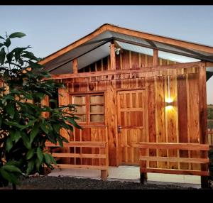 a wooden cabin with two benches in front of it at Hotel cabanas bom Jesus in Ametista do Sul