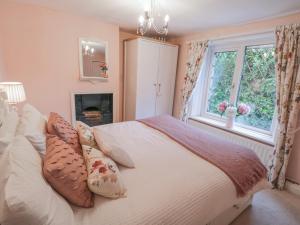 um quarto com uma cama com almofadas e uma janela em Laurel Cottage em Guisborough