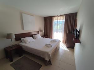 um quarto com uma cama grande e uma janela em Salgados Beach&Golf - Praia dos Salgados em Albufeira