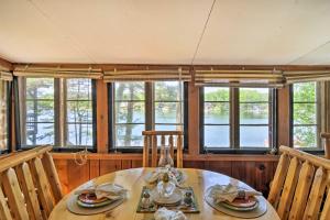 comedor con mesa, sillas y ventanas en Northern Michigan Lake House with Boat Dock and Kayaks, en Lake