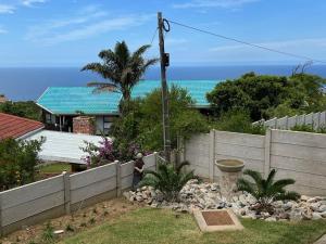 a fence in front of a house with the ocean at Tulip On The Bay in Mossel Bay
