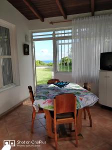 サンタンヌにあるCocooning sur mer Bungalowのテーブルと椅子と窓のあるダイニングルーム