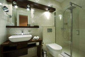 Un baño con lavabo, inodoro y ducha. en Hotel Soa, en Žabljak