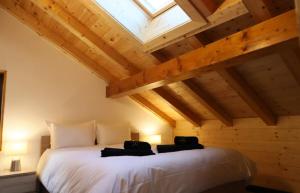 a bedroom with a large white bed with a skylight at Cosy&star in Salvan