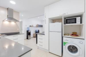 a kitchen with a washing machine and a microwave at Playa - PLAZA AYUNTAMIENTO ALICANTE in Alicante