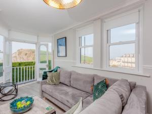 a living room with a couch and two windows at 2TheVilla - Great views, 3 bedrooms, parking, central location in Ilfracombe