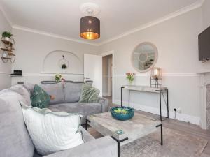 ein Wohnzimmer mit einem Sofa und einem Tisch in der Unterkunft 2TheVilla - Great views, 3 bedrooms, parking, central location in Ilfracombe
