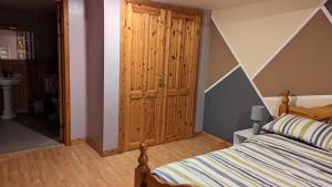 a bedroom with a bed and a wooden closet at One bedroom self-contained accommodation in Lerwick
