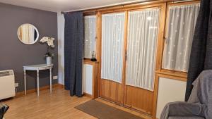 a living room with windows and a chair and a table at One bedroom self-contained accommodation in Lerwick
