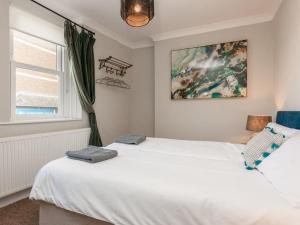 1 Schlafzimmer mit 2 weißen Betten und einem Fenster in der Unterkunft 2TheVilla - Great views, 3 bedrooms, parking, central location in Ilfracombe