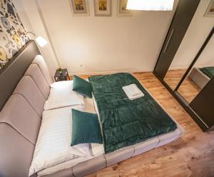 a bed with a green blanket on it in a room at Apartament Marklissa in Leśna