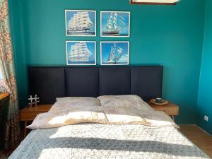 a bedroom with a bed with four pictures on the wall at Sunny Apartament in Reda