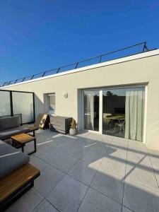 taras z kanapą i stołem w obiekcie Appartement T2 neuf - Grande Terrasse de 25m2 w mieście Saint-Priest