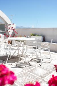 una mesa blanca y sillas en un patio con flores en Hotel Ghala Salta en Salta