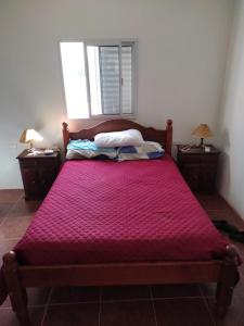 - un lit avec une couette rouge dans une chambre dans l'établissement Quinta en Alvear, à General Alvear