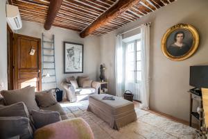 a living room with a couch and a mirror at Made in Lourmarin in Lourmarin