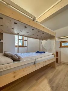 ein großes Etagenbett aus Holz in einem Zimmer in der Unterkunft Mon Raccard Cosy - 4 vallées in Bruson