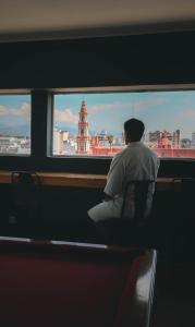 un hombre sentado en un tren mirando por la ventana en Hotel Ghala Salta en Salta