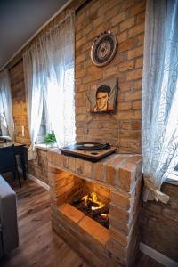 a living room with a stone fireplace with a picture on the wall at Apartament Marklissa in Leśna