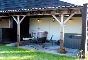 a pergola with a table and chairs on a patio at Wellness Bed & Breakfast by Leef in Maasland