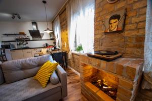 uma sala de estar com uma parede de tijolos e uma lareira em Apartament Marklissa em Leśna