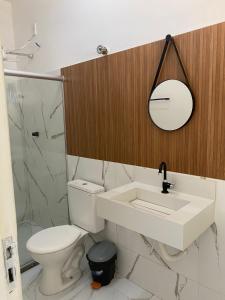 een badkamer met een toilet, een wastafel en een spiegel bij Portal do Sol in Itaberaba