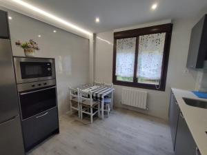 a kitchen with a stove and a table in it at Piso Bilbao San Mamés in Bilbao