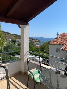 een patio met een glazen tafel en stoelen op een balkon bij Apartment Patricia in Primošten