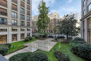 um jardim no meio de uma cidade com edifícios em Montaigne Executive Suite em Paris
