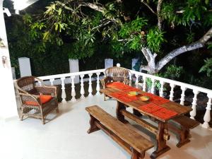 Un Paraíso para disfrutar y compartir cerca de Bogotá في ميلغار: طاولة خشبية وكرسي على الشرفة