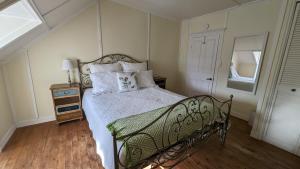 a bedroom with a bed with a metal frame and a window at La Gentilhommière Motel et Suite A Vue sur Mer in Saint-Siméon