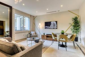 uma sala de estar com um sofá e uma mesa em Montaigne Executive Suite em Paris