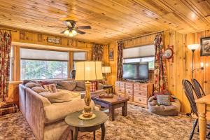 ein Wohnzimmer mit einem Sofa und einem TV in der Unterkunft California Retreat with Deck, Fire Pit and Grill! in Long Barn