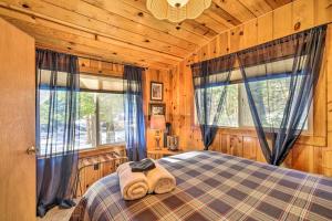 ein Schlafzimmer mit einem Bett in einem Blockhaus in der Unterkunft California Retreat with Deck, Fire Pit and Grill! in Long Barn