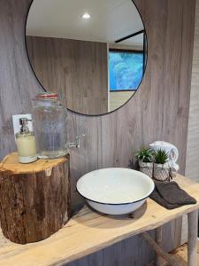 baño con lavabo sobre una mesa de madera con espejo en Bulle Time Flies - logement insolite, en Bouillon