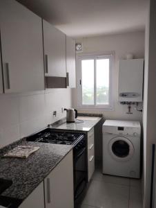 a kitchen with a stove and a washing machine at Buena Vista in Río Cuarto