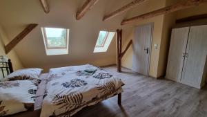 1 dormitorio con 2 camas y 2 ventanas en Apartmány Sebastián en Pribylina