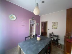 a dining room with a table and a purple wall at La casa di Marta in Valeggio sul Mincio