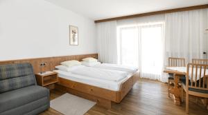 a bedroom with a bed and a couch and a chair at Gästehaus Luise in Waidring +39 photos